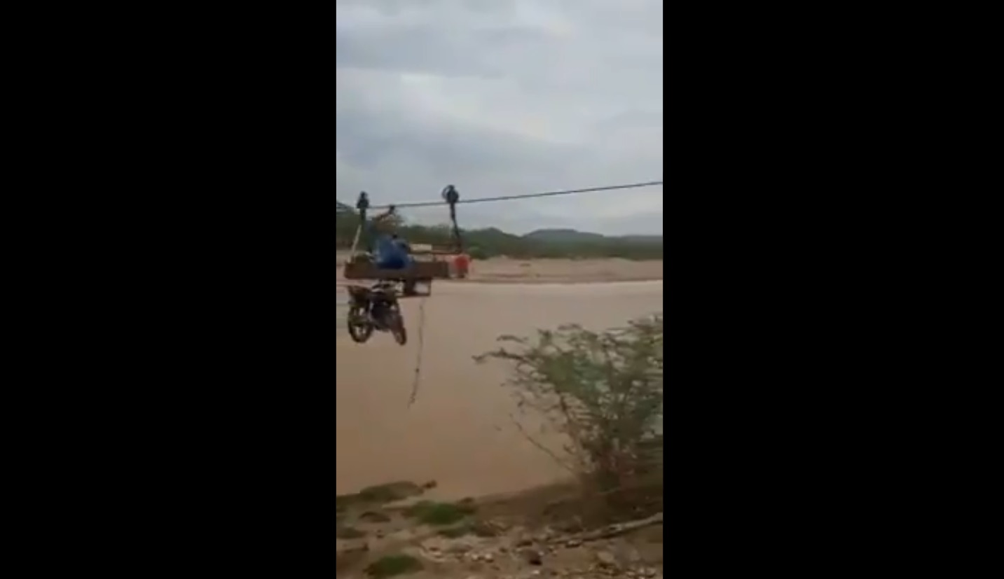 Un hombre se desplazó con su moto por una guaya para cruzar un río crecido en Falcón