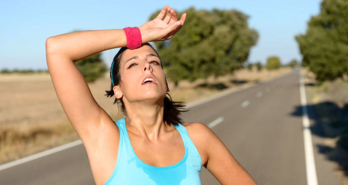 Tired woman sweating after running