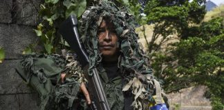 Ismaira Figueroa, francotiradora de la milicia bolivariana, lleva un rifle FAL de calibre 7,62 mm de fabricación belga. (Foto de Yuri CORTEZ / AFP).