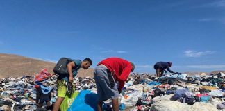 Venezolanos recogen prendas en un basural de ropa en Atacama