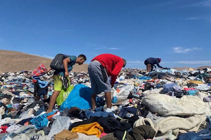 Venezolanos recogen prendas en un basural de ropa en Atacama
