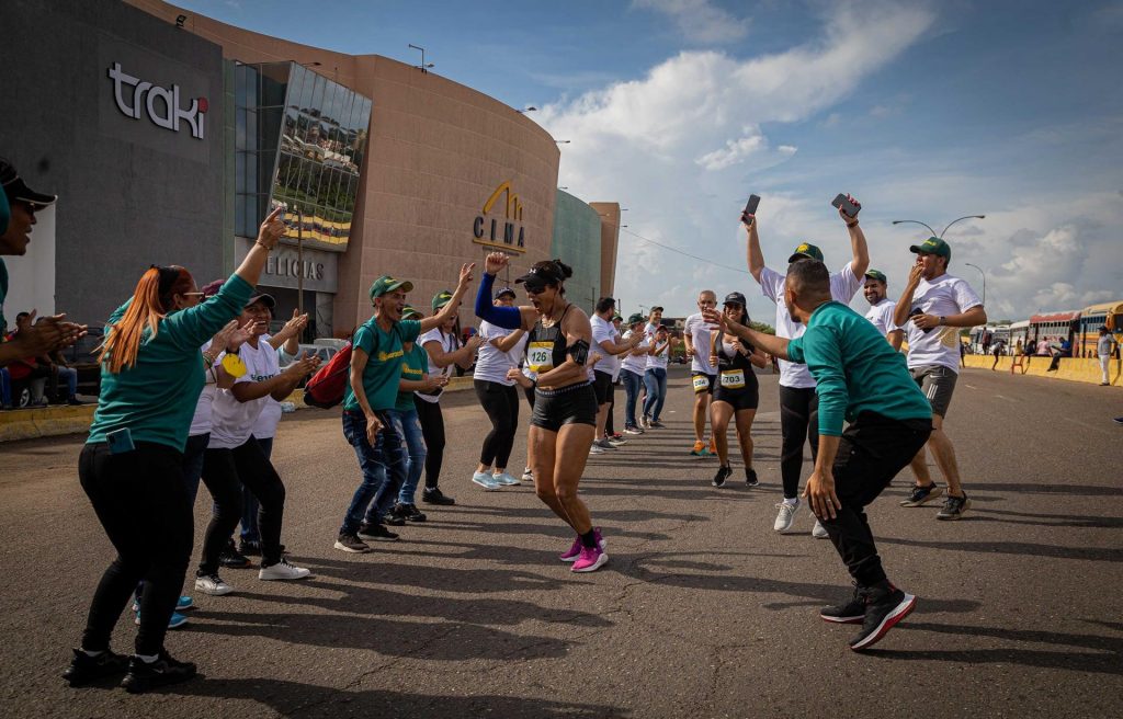 Personas alientan a una corredora hoy, en la Media Maratón 2022 de Maracaibo, estado Zulia (Venezuela)