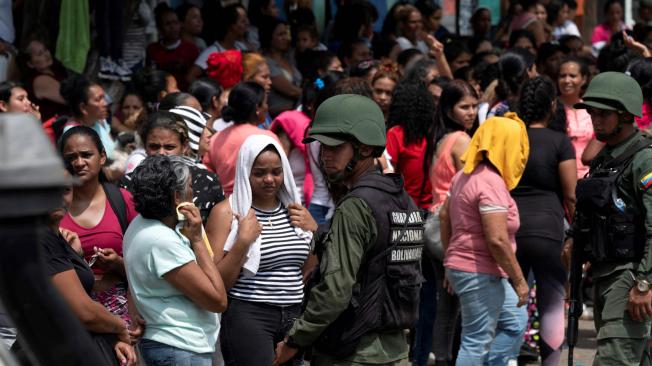 La Guardia Nacional Bolivariana monta guardia mientras familiares esperan noticias después de que las autoridades tomaran el control de Tocorón. Foto: AFP Tren de Aragua