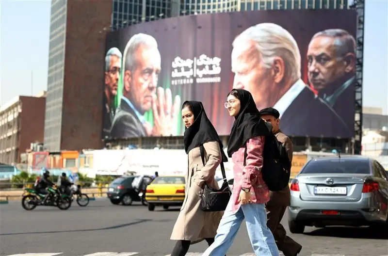 Una valla publicitaria en Teherán muestra al presidente iraní y a un líder de la Guardia Revolucionaria frente a Biden y Netanyahu.