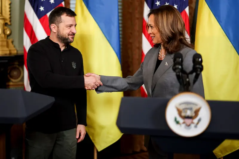 Volodymyr Zelensky y Kamala Harris se dan la mano.