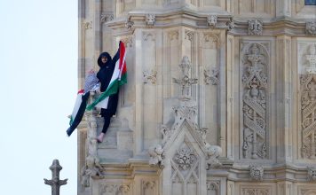 Un hombre con una bandera palestina escala la torre del Big Ben en Londres